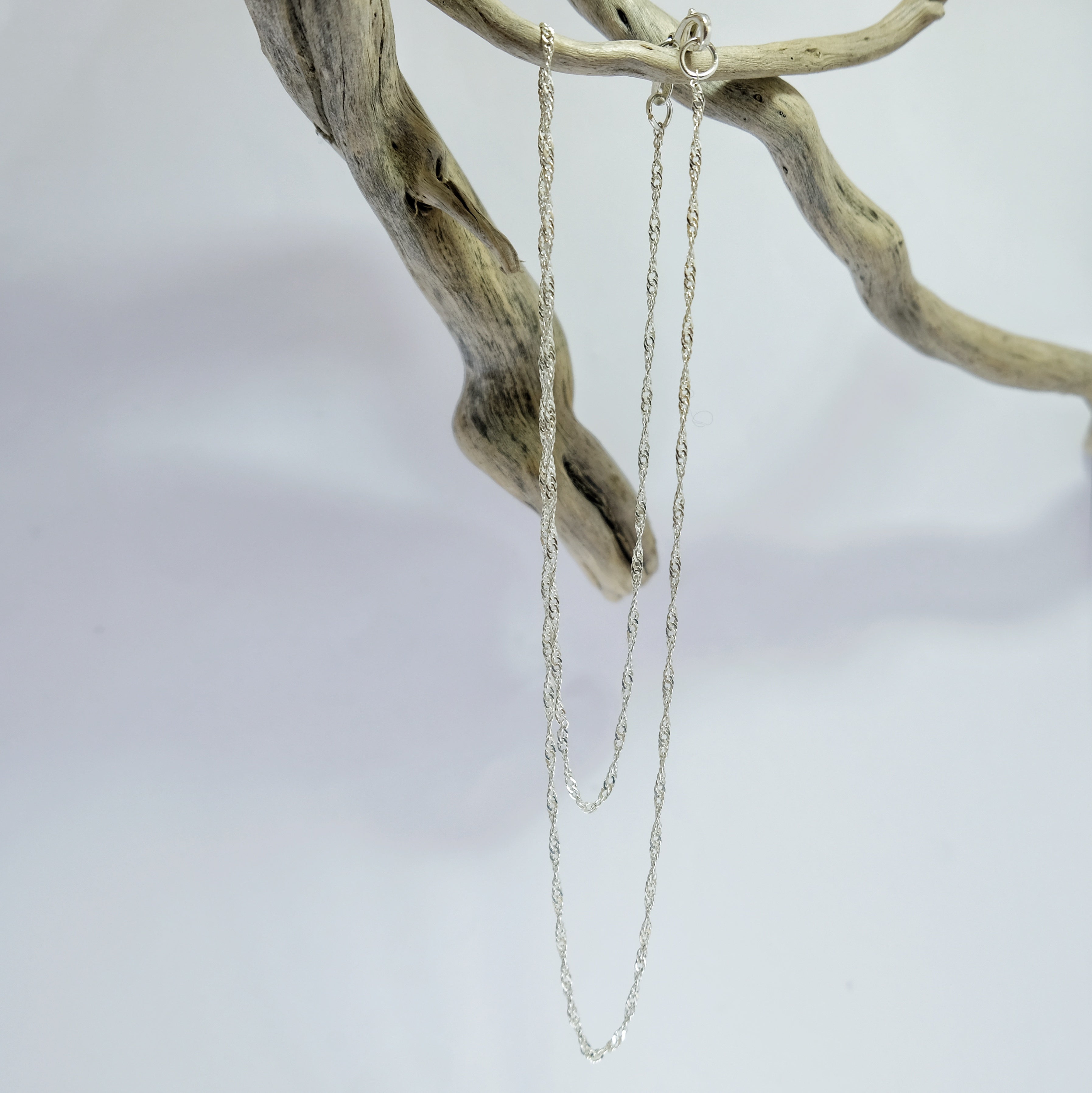 Delicate silver twist chain draped over driftwood | Made with Grace | handmade jewellery nz