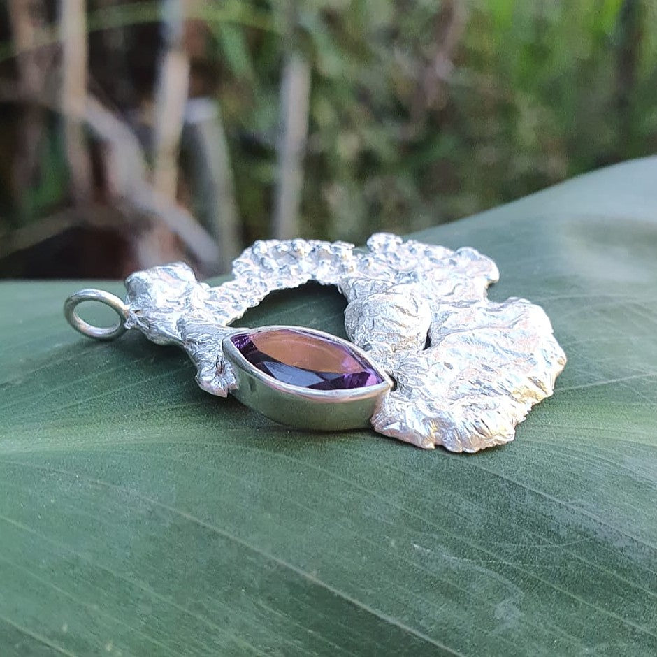 Silver and purple gemstone large pendant, shown from the side lying on a leaf| Made with Grace | handmade jewellery nz