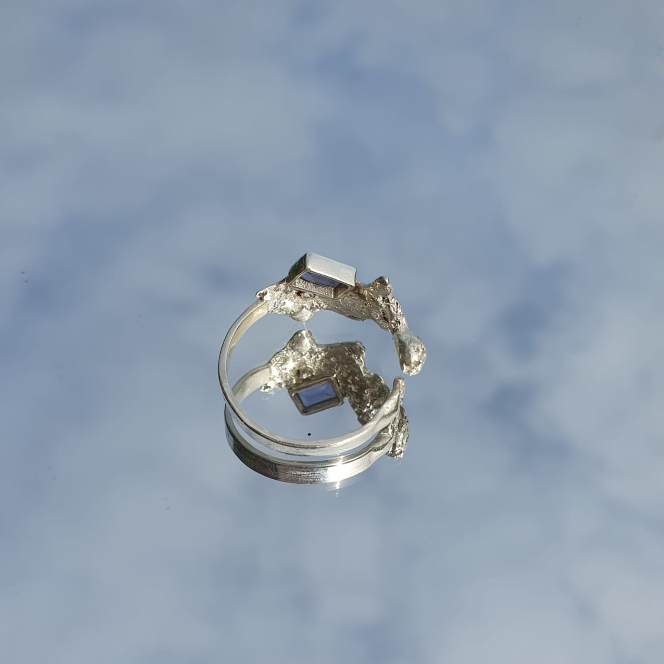 Silver and blue gemstone ring amongst a blue sky, shown from behind | Made with Grace | handmade jewellery nz
