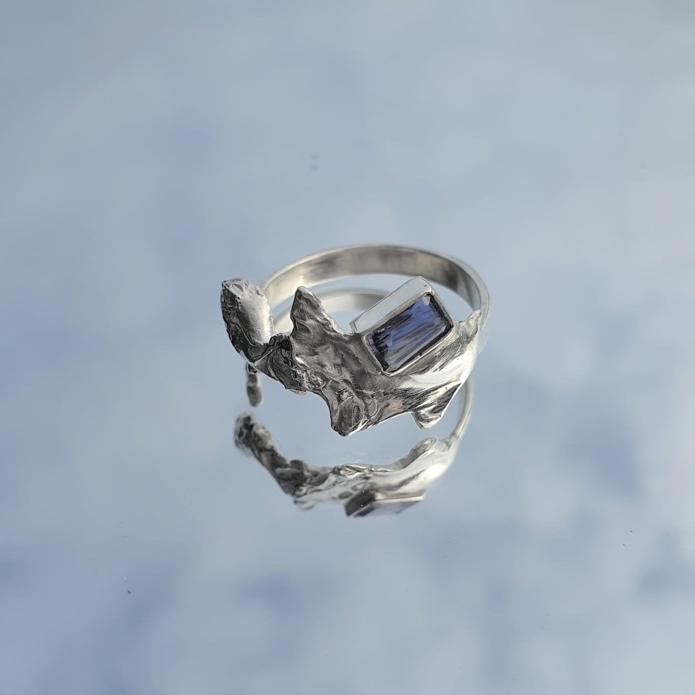 Silver ring with rectangle blue gemstone amongst a cloudy blue sky | Made with Grace | handmade jewellery nz