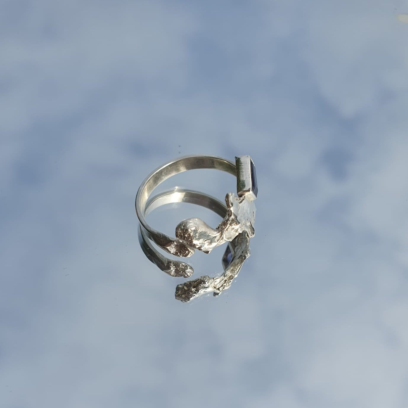 Silver and blue gemstone ring amongst a blue sky, shown from the side | Made with Grace | handmade jewellery nz
