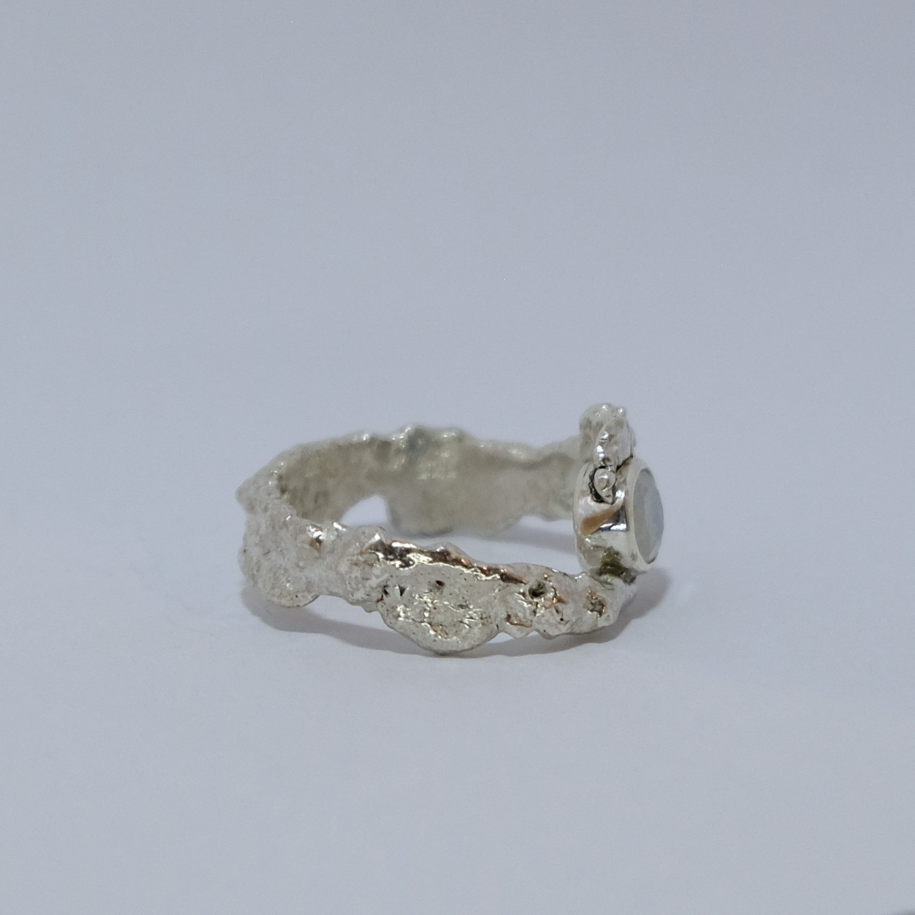 Rainbow moonstone ring, gemstone wrapped in silver, shown from the side | Made with Grace | handmade jewellery nz