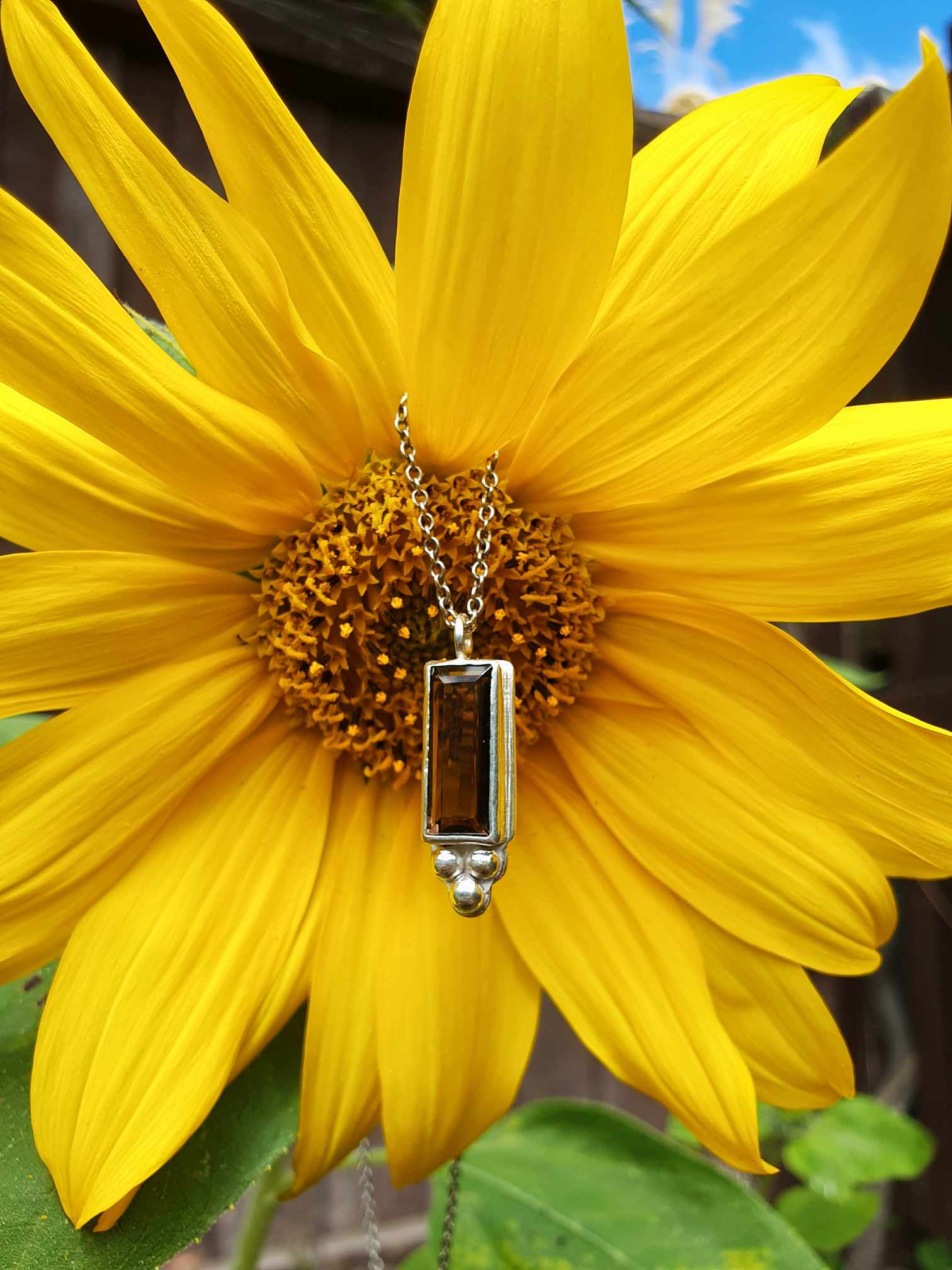 Rectangle silver and brown gemstone necklace with silver accents in front of sunflower | Made with Grace | handmade jewellery nz